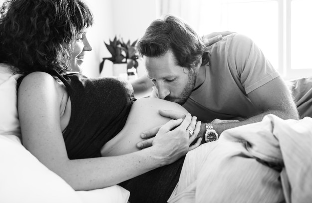 Husband kissing a baby bump