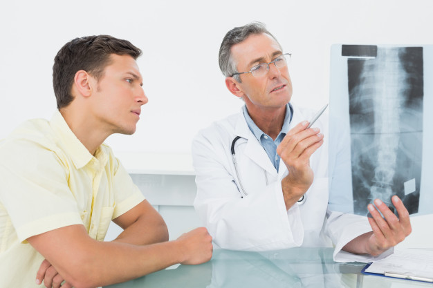 medico-che-spiega-i-raggi-x-della-colonna-vertebrale-al-paziente-in-ufficio_13339-263219