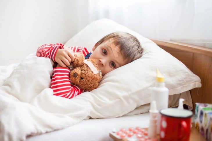 bambino al letto con orsetto